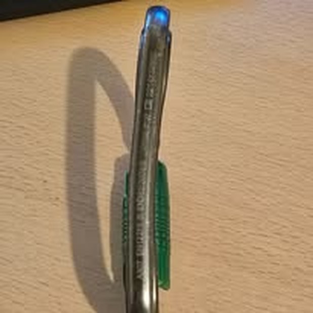 Aluminium karabiner seen side-on, bent out of shape from misuse