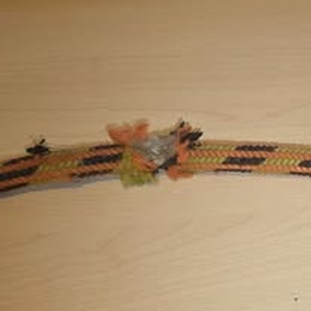 Orange and black braided rope with the sheath cut through and the inner core fibres exposed
